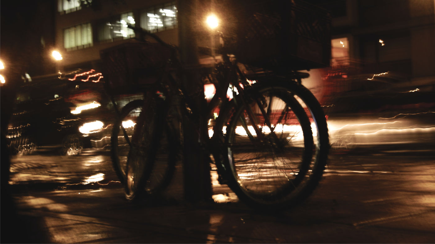 Cars lights on the street behind a bike